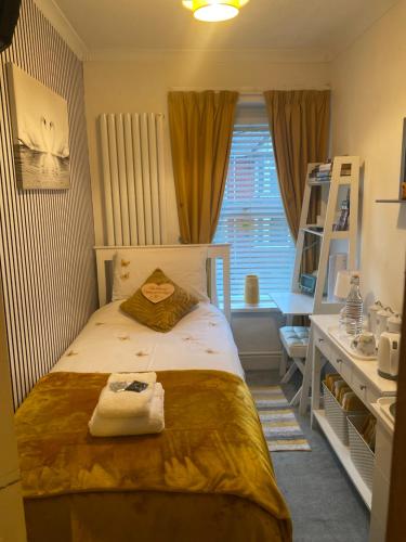 a bedroom with a bed and a desk and a window at Butterfly House in Blackwood