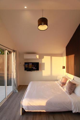 a bedroom with a large white bed and a lamp at Wawee Sunset, Doi Chang Chiang Rai in Ban Huai Khai