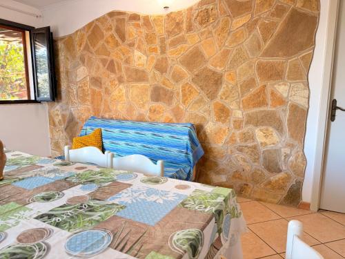 a room with a bed with a stone wall at Villa Flora Gallipoli in Il Monte