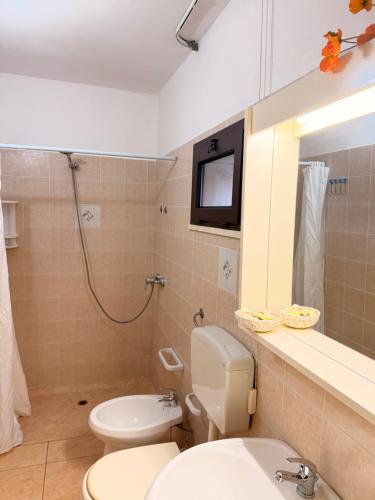 a bathroom with a toilet and a sink and a mirror at Villa Flora Gallipoli in Il Monte