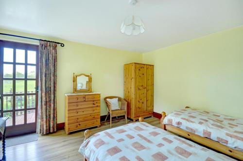 a bedroom with two beds and a dresser and a mirror at 3 Bed in St Columb oc-trembl in Saint Mawgan