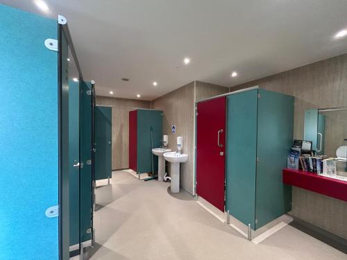 a bathroom with green and red stalls and a sink at Ronam Glamping 2 Berth Pod in Anderby