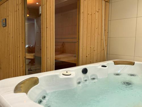 a white bath tub in a bathroom with a shower at Luxury Georgian Townhouse Tenby Sleeps 8 Parking Permit in Tenby