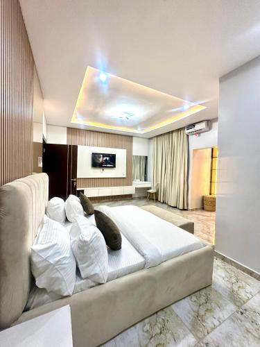 a bedroom with a large bed with white sheets at One bedroom apartment Presidential suite in Abuja