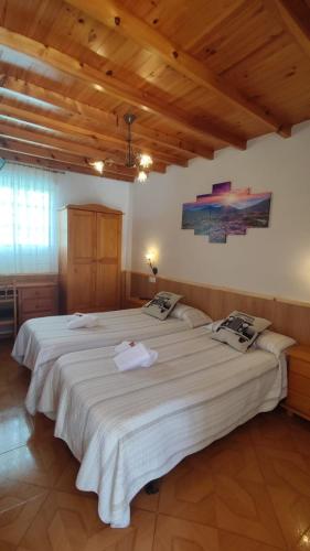 a large white bed in a room with wooden ceilings at Casa David in Treacastela
