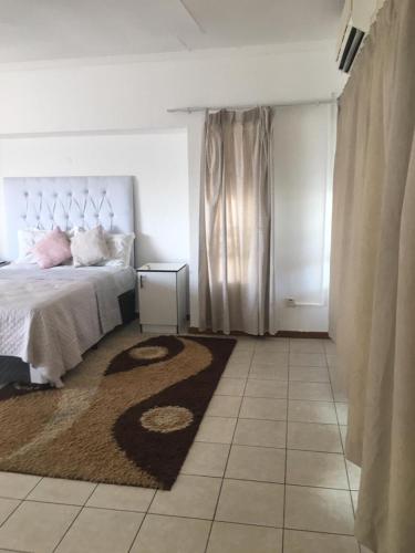 um quarto com uma cama grande e um tapete em Gaborone BnB em Gaborone