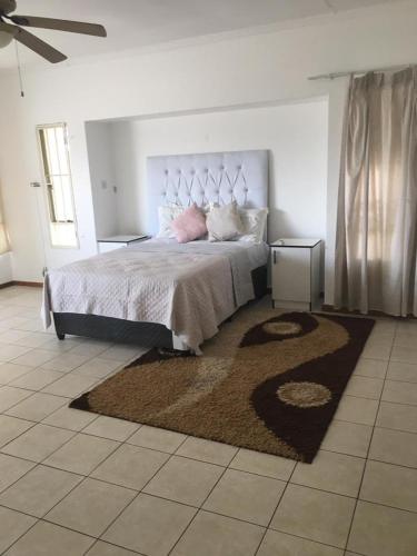 um quarto com uma cama grande e um tapete em Gaborone BnB em Gaborone