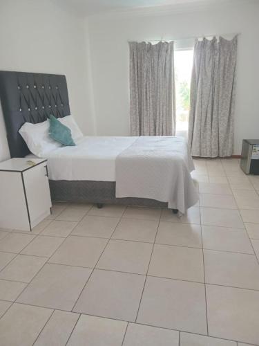 um quarto com cama e piso de azulejos em Gaborone BnB em Gaborone