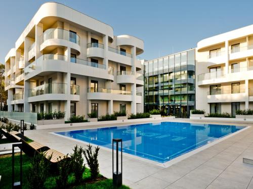 a building with a swimming pool in front of a building at Hotel LIDO in Jurata