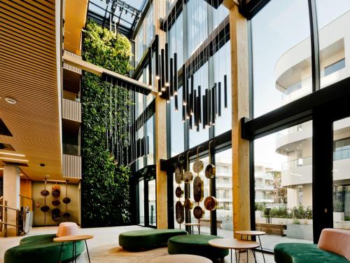 a lobby of a building with green seating and windows at Hotel LIDO in Jurata