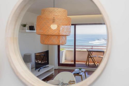 a room with a view of the ocean through a mirror at Liiiving in Matosinhos - Seaside Balcony Apartment in Porto