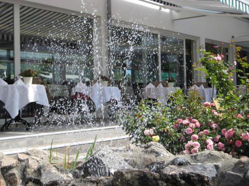 a fountain in a restaurant with tables and flowers at Parkhotel Flora am Schluchsee in Schluchsee