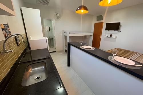 a bathroom with a counter with a sink at Central Praias Suíte 202 com ar, tv, frigobar, banheiro privativo, espaçosa em frente à praça in Cabo Frio