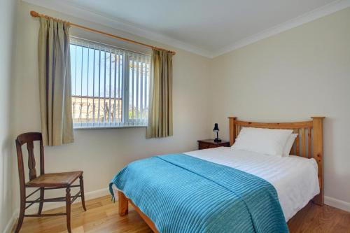 a bedroom with a bed and a chair and a window at 2 Bed in Attleborough oc-1277 in Old Buckenham
