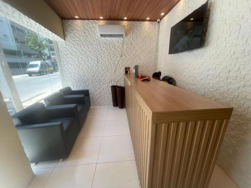 a lobby with a bar with couches in front of a building at Pousada Corais de Pajuçara- MCZ in Maceió