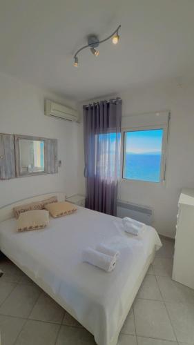 a bedroom with a large white bed with a window at Infinity View Villa Panoramic Aegean Siviri in Siviri