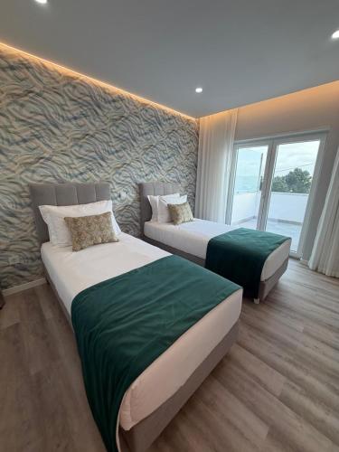 a hotel room with two beds and a window at Guesthouse Solar do Mar in Silveira