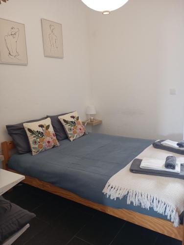 a bedroom with a bed with blue sheets and pillows at Apartamentos São Sebastião in Évora