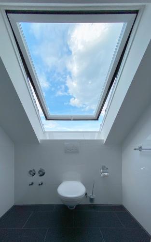 a skylight in a bathroom with a toilet at Midi-Maisonette mit kleiner Dachterrasse und Blick ins Grüne in Petersberg