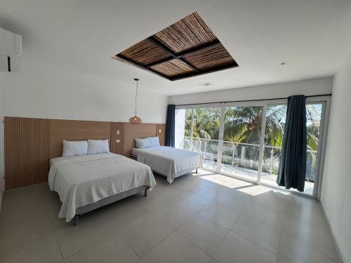 a bedroom with two beds and a large window at Hotel Paseo del Sol in La Paz