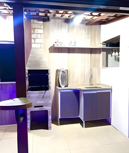 a kitchen with purple cabinets and a sink at Cobertura com piscina, sauna e churrasqueira in São Pedro da Aldeia
