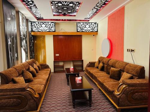 a living room with couches in a room at Hotel Rosewood Uttara in Kāmarpāra