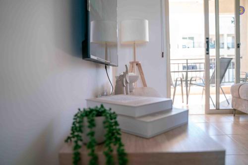 a living room with a couch and a table with a plant at Sunshine Royal Seacrest- Prime Location Paphos with Pool in Paphos
