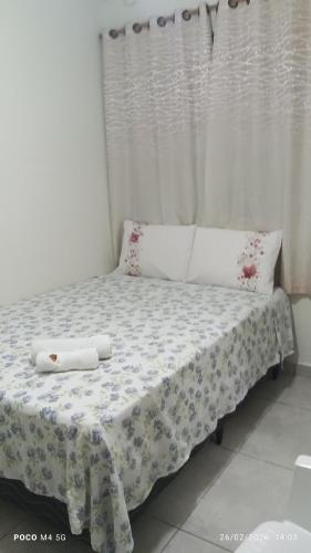 a bed with two pillows on it in a room at Pousada Santos 4, kitnet confortável com ar condicionado in Londrina