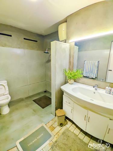 a bathroom with a sink and a toilet at Amandawa Eco in Gampaha