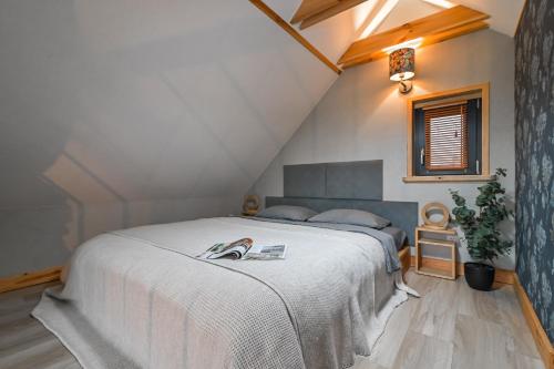a bedroom with a white bed with a book on it at Stark House Gallery in Borsk