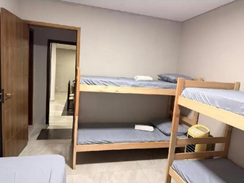 a room with three bunk beds and a mirror at Casa Dona Flor in Morretes