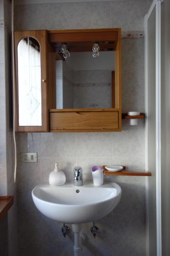 a white sink in a bathroom with a mirror at Fabbricato Indipendente Centro in Lozzo Cadore