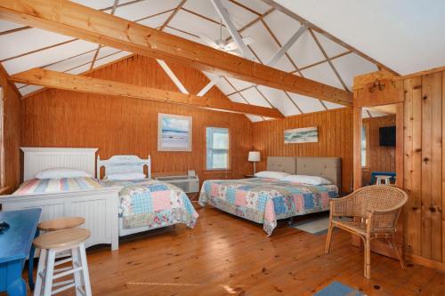 two beds in a room with wooden walls at NH330 It's Beach Time in Nags Head