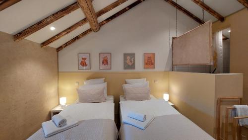 two beds in a room with white sheets at Refuge des Sottais in Burg-Reuland