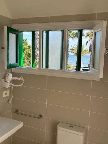 a bathroom with a toilet and a window with a view of the ocean at CASA MACA sea view & beach front in Puerto del Carmen