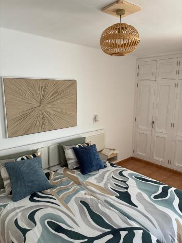 a bedroom with a large bed with blue pillows at CASA MACA sea view & beach front in Puerto del Carmen