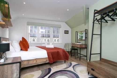 a bedroom with a bed and a desk and a window at Modern Town House Bangor City Centre in Bangor