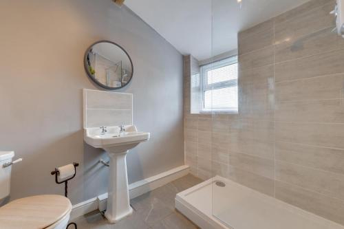 a bathroom with a sink and a toilet and a mirror at 2 Bed in Matlock oc-dcbeau in Crich