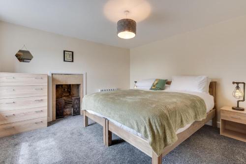 a bedroom with a large bed and a fireplace at 2 Bed in Matlock oc-dcbeau in Crich