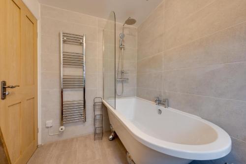 a bathroom with a white tub and a shower at 1 Bed in Crakehall oc-ds955 in Crakehall