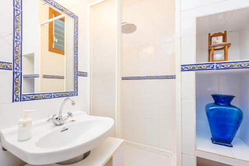 a bathroom with a sink and a blue vase at Es Raco in Caimari