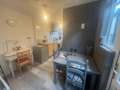 a small kitchen with a table and a desk at One Bedroom Apartment Filton in Bristol