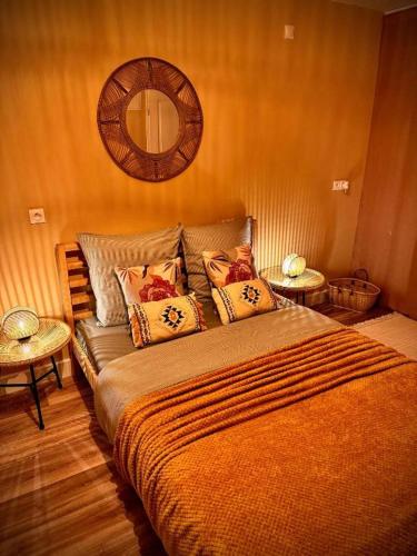Bohème - Maison entièrement privée في سان جان دي براي: غرفة نوم بها سرير ومرآة على الحائط