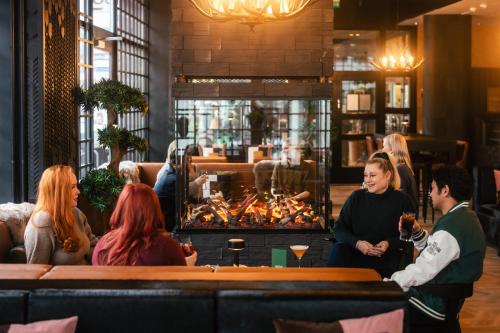 a group of people sitting around a bar in a restaurant at Santa's Hotel Santa Claus in Rovaniemi