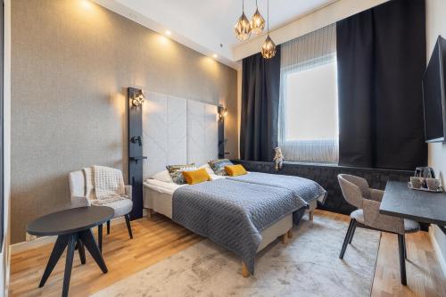 a bedroom with a bed and a table and chairs at Santa's Hotel Santa Claus in Rovaniemi