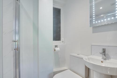 a white bathroom with a shower and a sink at 1 Bed in Gunnerside oc-ds1016 in Gunnerside