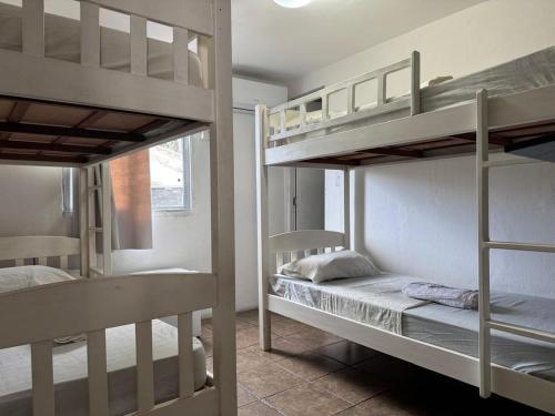 two bunk beds in a small room with a bed at Casa Aeroporto Pousada in Recife