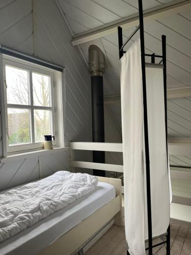 a bedroom with a bed and a window at Eilantgeluk in Oudesluis