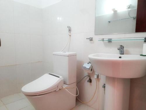 a bathroom with a pink toilet and a sink at Sunset Araliya by Diyakawa in Aluthgama
