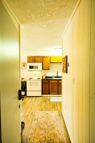 a kitchen with white appliances and wooden cabinets at Snowbound Bliss at Powderhorn Mountain in Bessemer